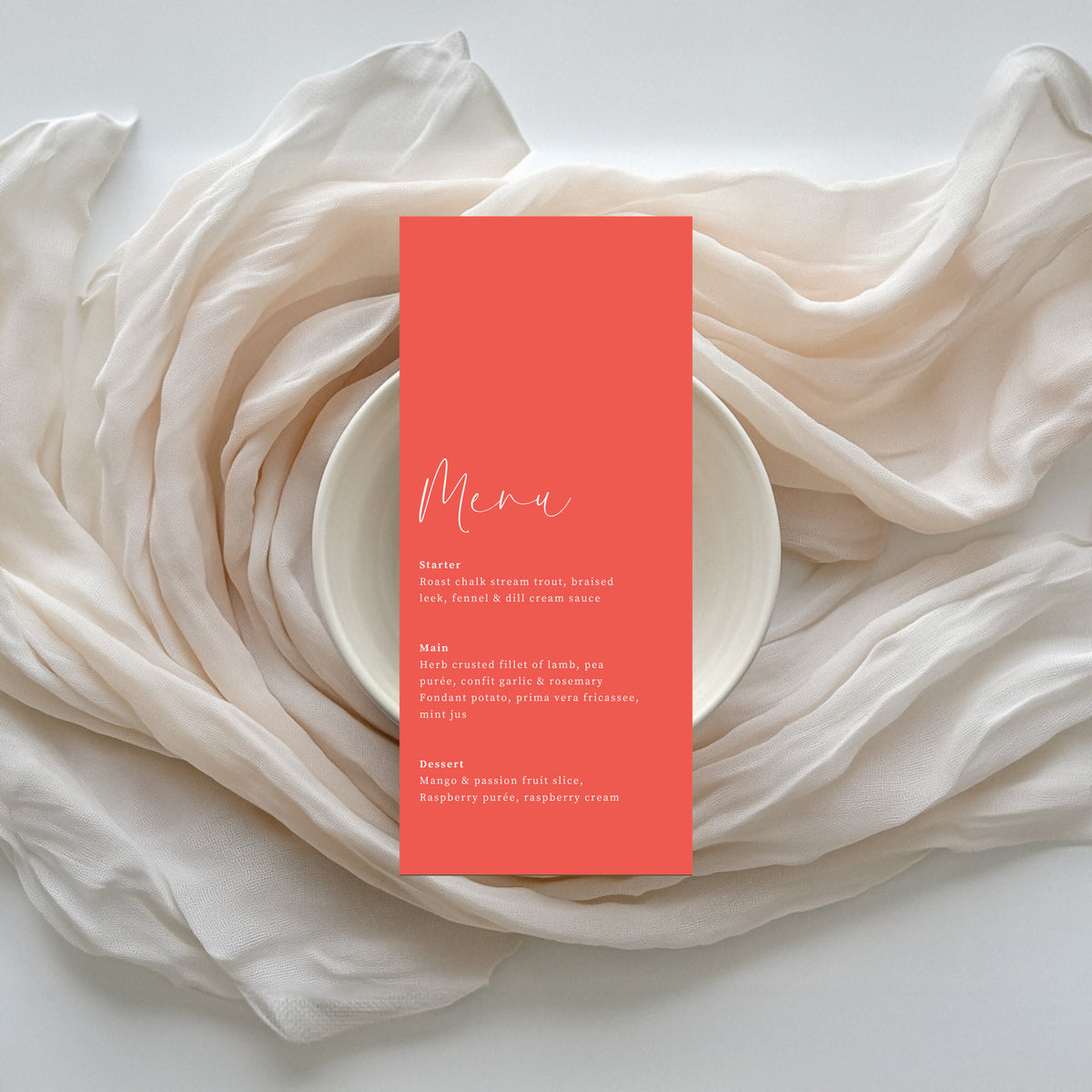 Willow personalised coral wedding menu on ivory silk linen backdrop.